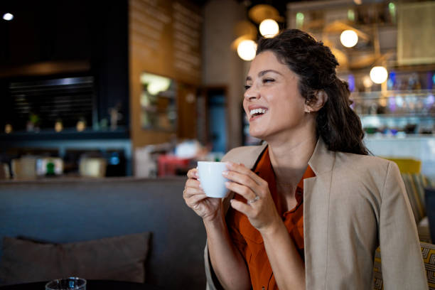 istock Laughing woman holding a coffee cup in a cafe 2167188785