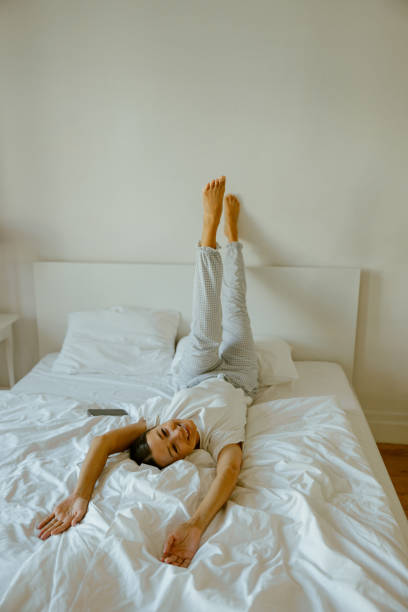 istock Enjoying a Relaxing and Comfortable Posture on the Bed with Legs Up, in a Bright Room 2167200146