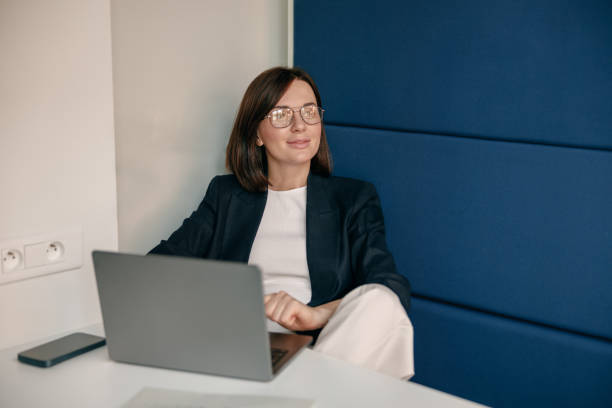istock A businesswoman in a modern office is focused on laptop work, displaying confidence 2167200492
