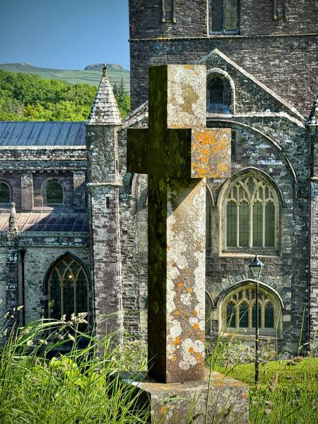 a stone shaped cross marks an eternal cemetery plot on the grounds of st davids cathedral in pembrokeshire