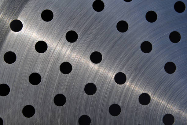 Metallic surface with a pattern of circular holes abstract textured background