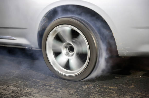 istock Drag racing car is burning tires at start line. 2167217100