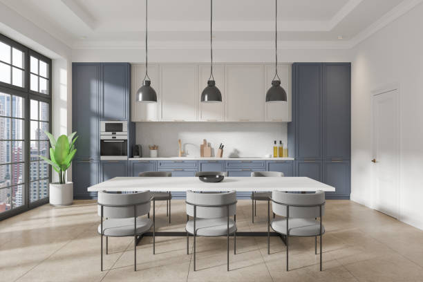 istock White and blue home kitchen interior with dinner table and cabinet, window 2167230886