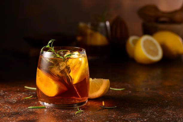 istock Iced tea with ice, rosemary and lemon slices on a brown table. 2167231139