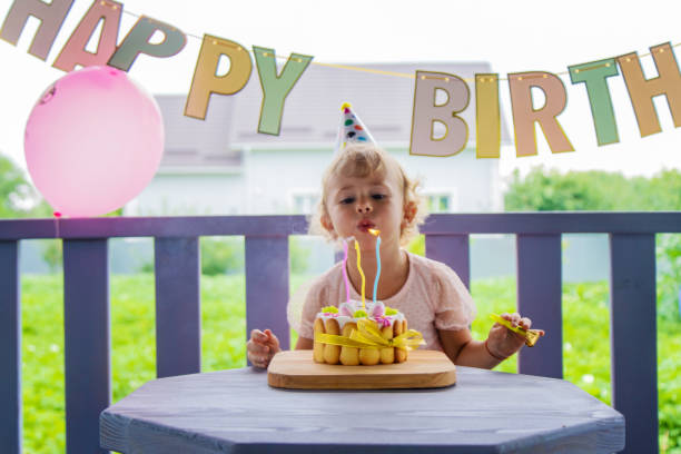 istock A three year old child blows candles on a cake. Selective focus. 2167232128