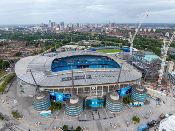 An aerial view of the Etihad Stadium in Manchester, Greater Manchester UK showing  construction underway on a new stand and surrounding areas.