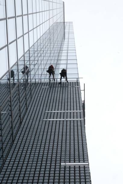 Unrecognizable worker working as a window cleaner on a modern high rise building.
