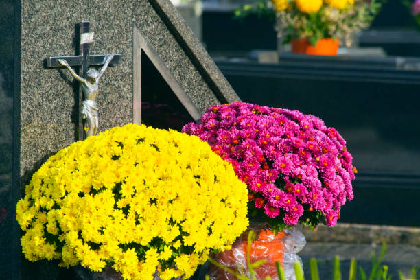 istock Stone tombstone and flowers in a graveyard. 2167240274