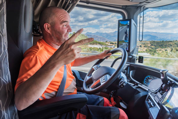 istock Truck driver driving on the highway with a happy expression and his hand making a V because everything has gone well for him. 2167243280