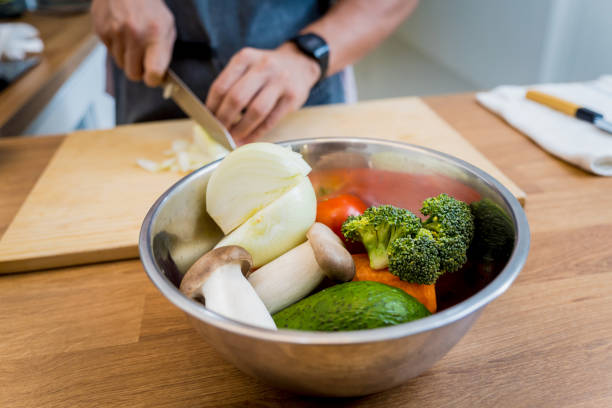 Chef at the kitchen preparing healthy quinoa bowl with avocado.