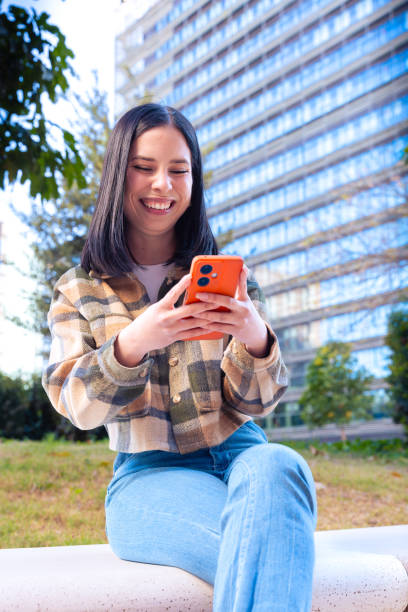 istock Woman browsing the internet using mobile device outdoors. 2167246472