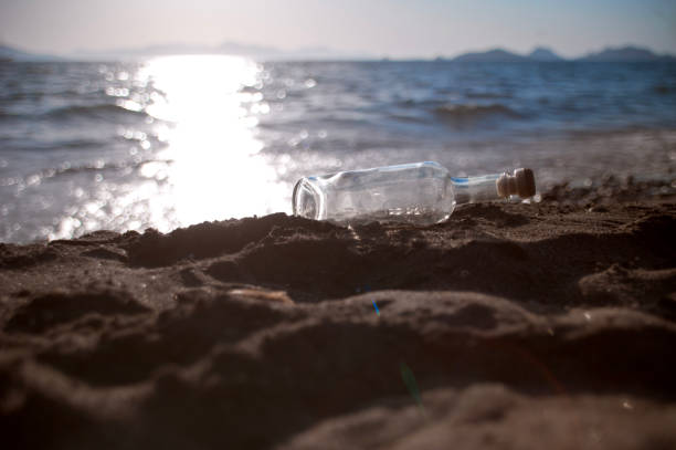 High angle view of an empty beer bottle left on concrete railing next to El Cabanyal urban beach in the city of Valencia, Spain