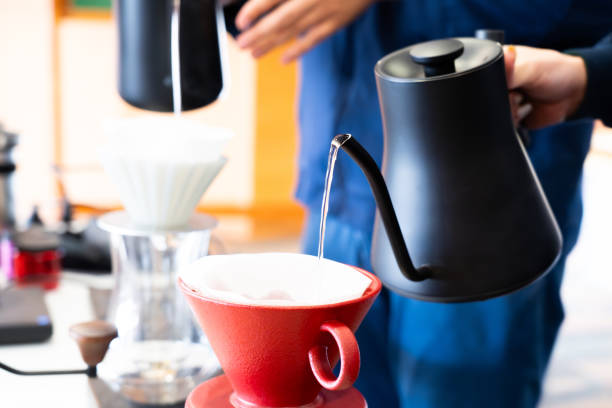 istock Pouring hot water while brewing coffee with a handmade drip coffee maker on a wooden table in the morning 2167247179