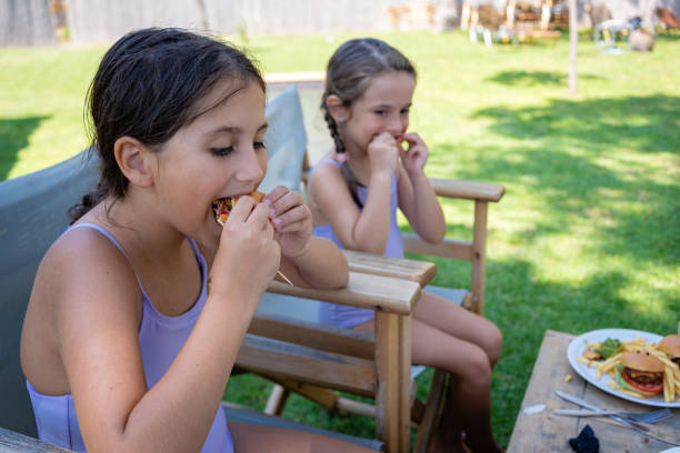 istock A relaxed moment between two little sisters, each enjoying their burger 2167247603