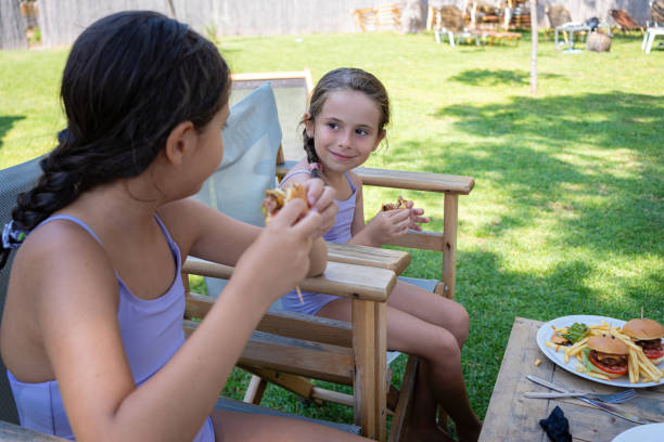 istock Little smiling sisters enjoy summer days in the shade 2167247606