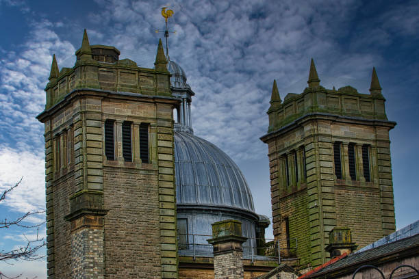 Dramatic sky over twin stone towers with a metallic dome, showcasing architectural details and moody ambiance in Harrogate, England.