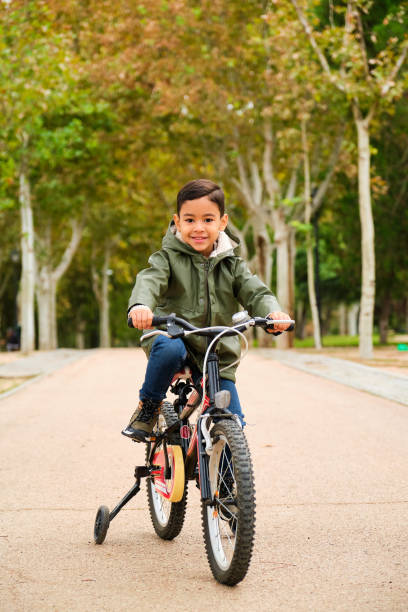 istock Latin five years old boy riding his bicycle in a park in a fall day. 2167248135