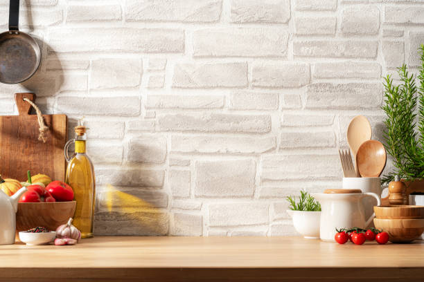 Kitchen countertop with utensils, vegetables and spices on brick wall background. Copy space available