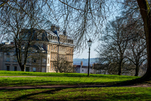 istock Historic building seen through trees in a lush park with sunlight filtering through the foliage. 2167253895