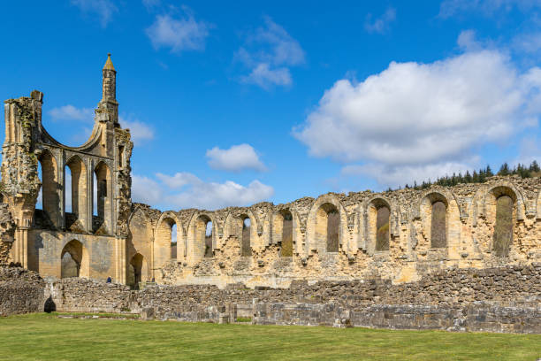 istock Ancient ruins under blue sky with clouds, grass in foreground. Historic architecture concept at Byland Abbey 2167254313