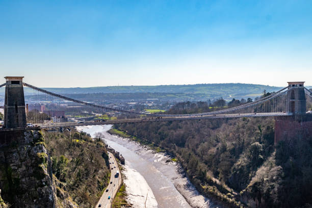 istock Suspension bridge over a scenic gorge with a river, under a clear blue sky in Bristol. 2167254314