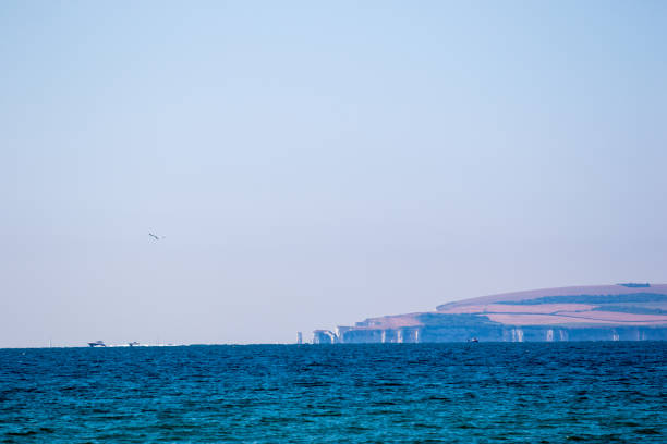 Serene seascape with calm blue waters and distant cliffs under a clear sky, ideal for backgrounds and nature themes in Bournemouth, England.
