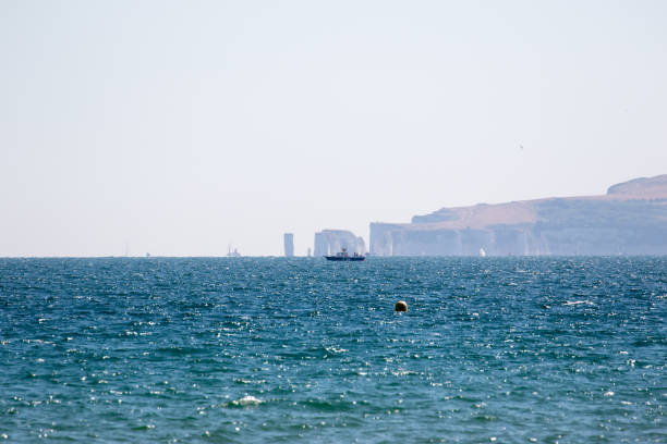 Serene seascape with distant cliffs and buoy on a clear day in Bournemouth, England.