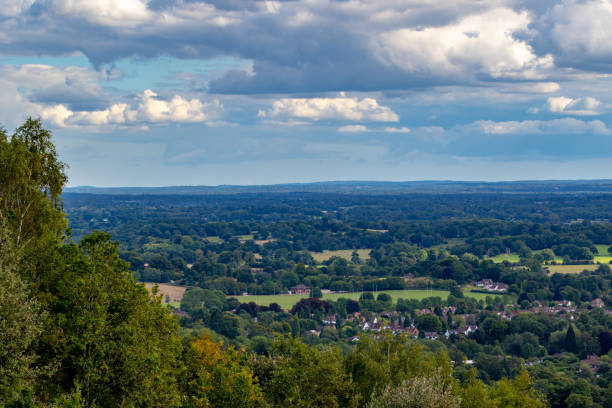 istock Breathtaking view of a lush green valley under a dynamic sky with scattered clouds. 2167256006