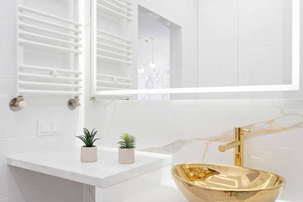 istock Home interior with ceramic bathroom sink on cupboard with gold water tap and tile on the wall with marbled effect.  Interior decor. 2167256131