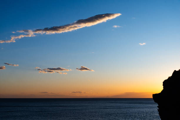 Peaceful sunset over the Mediterranean Sea with a silhouette of a cliff, capturing the beauty of twilight in Cinque Terre.