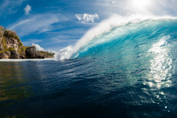 Blue wave in ocean. Breaking barrel wave with sunlight