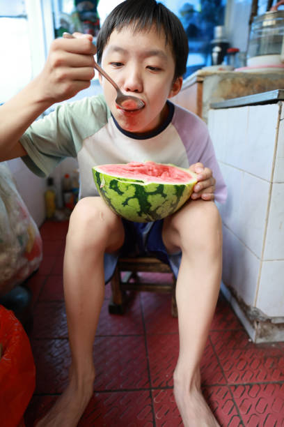 Little boy eating watermelon in the old kitchen