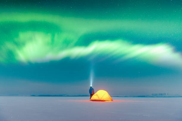 istock Tourist with flashlight near yellow tent 2167270201