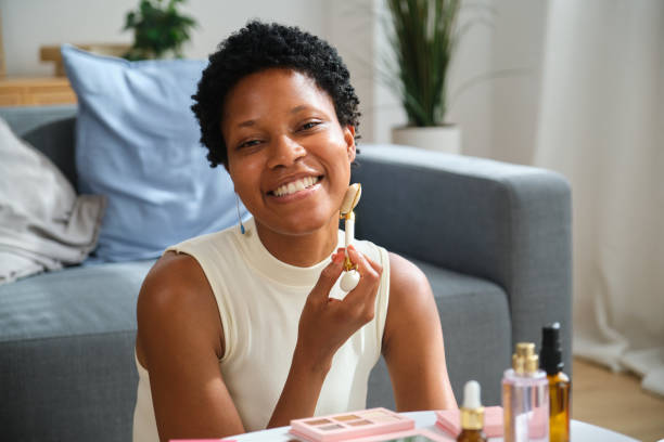 istock Beautiful mixed race woman using jade roller massaging face at home 2167271477