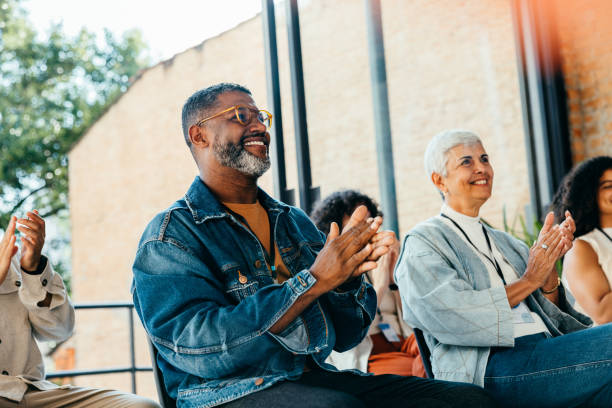 Smiling staff clapping in appreciation during a meeting