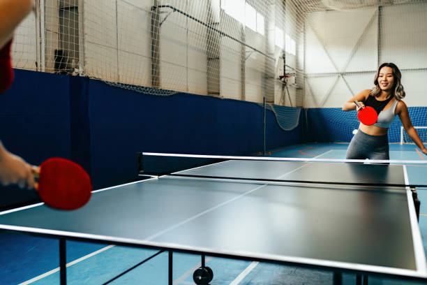 istock Focused athletic woman showcasing agility and concentration while playing competitive table tennis in a sports facility with blue walls 2167281863
