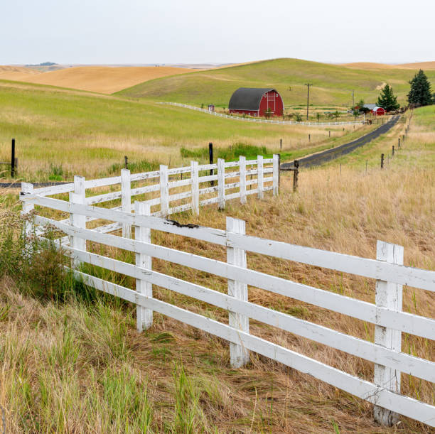 Farm land with red barn and white picket fence