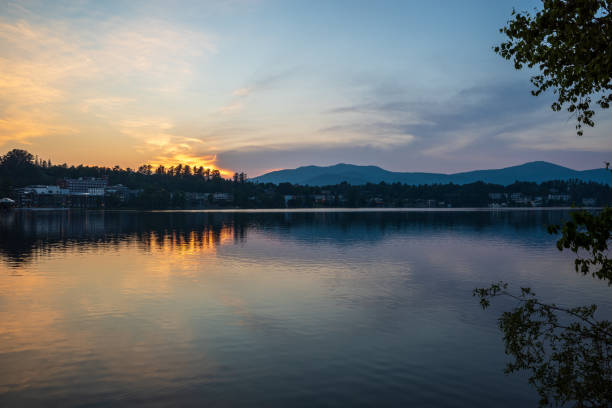 Sunset over Lake Placid with Adirondack Mountains in the background across Mirror Lake in Upstate New York, USA. stock photo