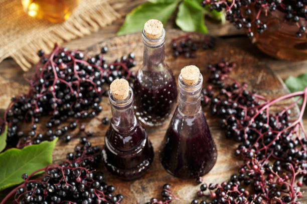 istock Black elderberry syrup in three glass bottles on a table 2167292975
