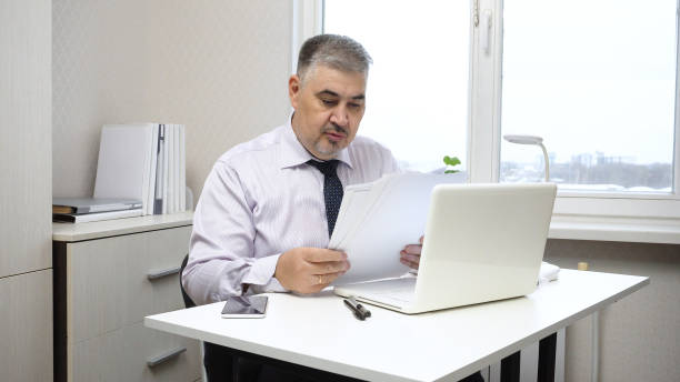 istock Businessman at Desk in Office Working with Documents 2167296469
