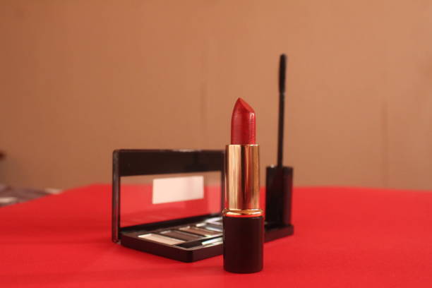 Lipstick on a red background with space for text copy space side angle. Beauty Background Decorative Cosmetics.