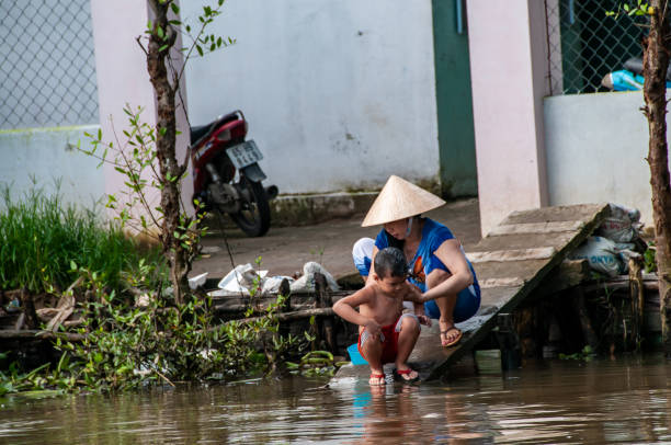 Cai Rang, Can Tho, Vietnam - nov 20, 2013: a young mother clean her child in a canal in the immense Mekong delta, near Cai Rang, Can Tho