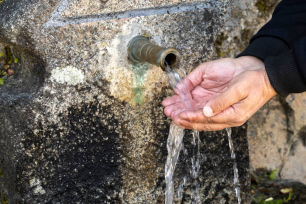 istock Hands of a man in an ancient fountain 2167304314