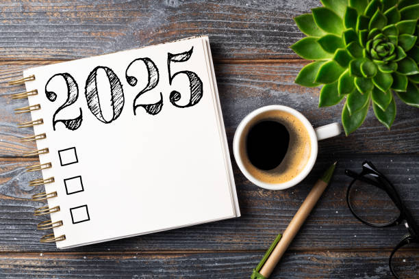 istock New year resolutions 2025 on desk. 2025 resolutions list with notebook, coffee cup on table. Goals, resolutions, plan, action, checklist concept. New Year 2025 template 2167307713