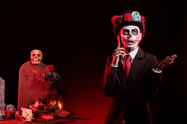 istock Dark lady wearing formal suit talking on phone during Dia de los Muertos 2167311702