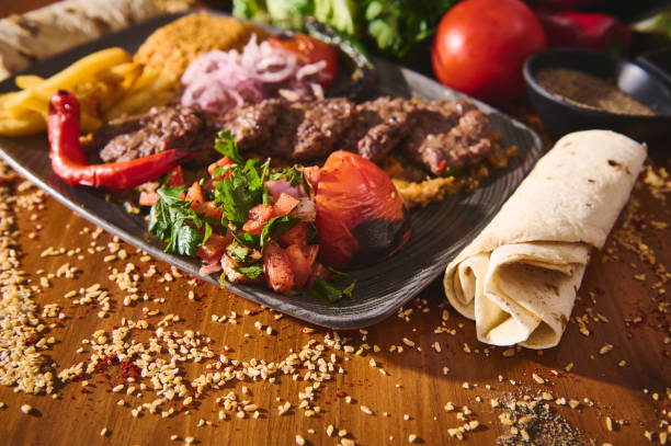 istock Delicious Middle Eastern food platter with grilled kebabs, fresh salad, and flatbread on a wooden table showcasing authentic flavors and vibrant presentation. 2167312503