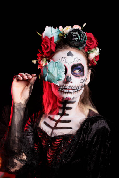 istock Woman posing with blue rose while wearing skeleton makeup 2167312832