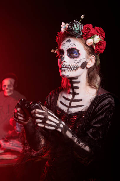 istock Dark lady playing videogames with controller during Dia de los Muertos 2167312943