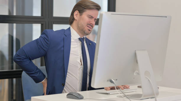 istock Young Businessman with Spinal Injury Working on Desktop 2167314143