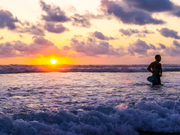Nosara, Costa Rica - February 5, 2024: Surfer on Guiones Beach at sunset.